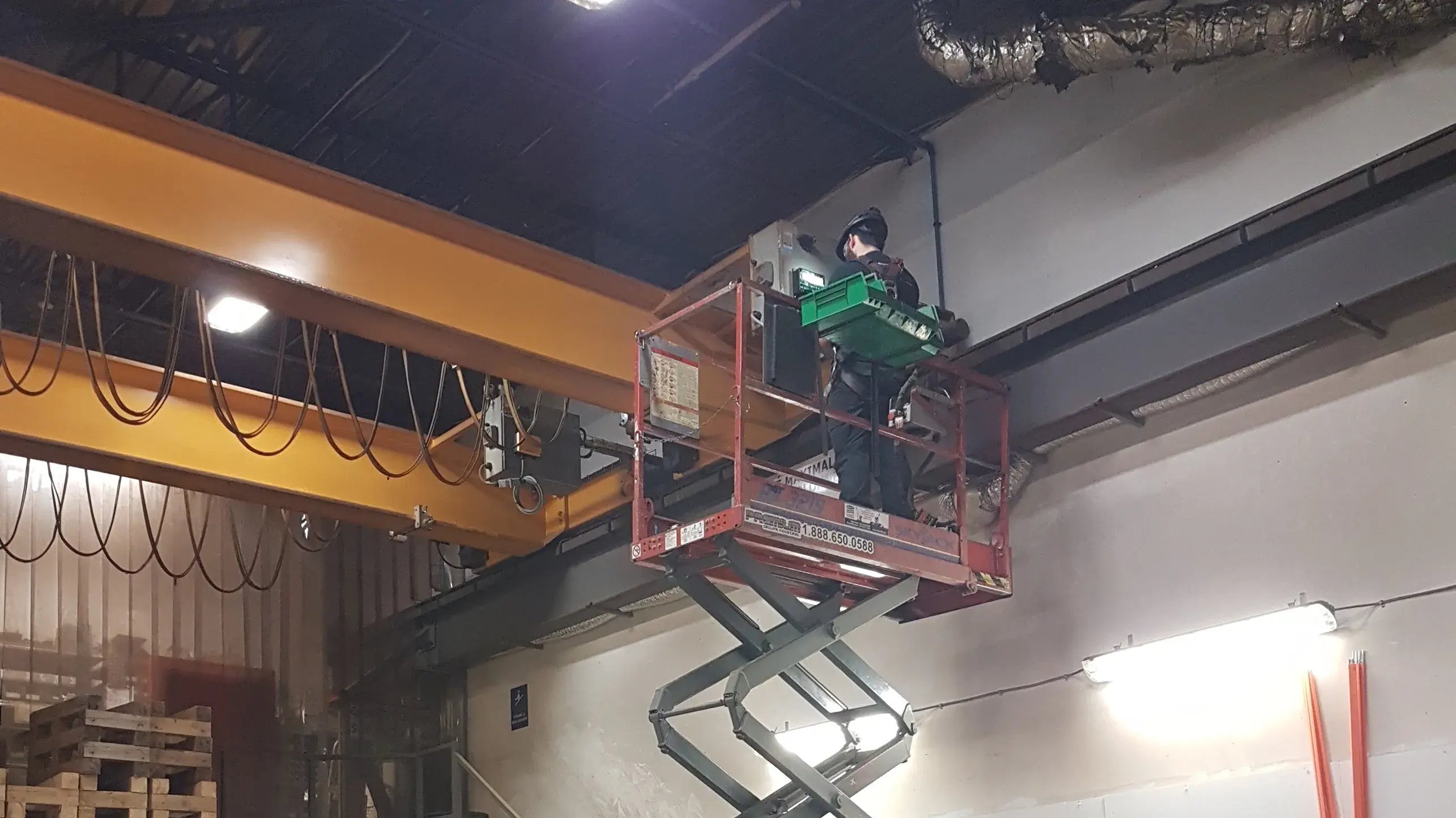 un technicien dans une nacelle effectuant l'inspection d'un pont roulant