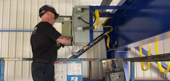 technician performing maintenance on an overhead crane