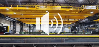horn logo against a background of overhead cranes