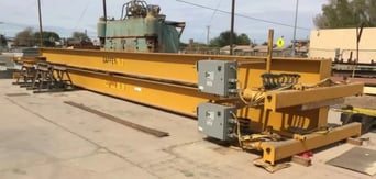 two overhead cranes on the ground in a courtyard
