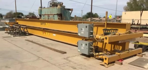 two overhead cranes on the ground in a courtyard