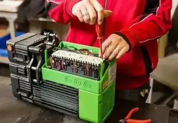 technicien de service de ponts roulants effectuant le service sur un palan industriel