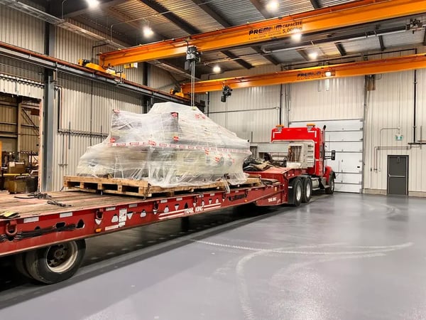 palan d'un pont roulant soulevant une lourde charge d'un camion de transport